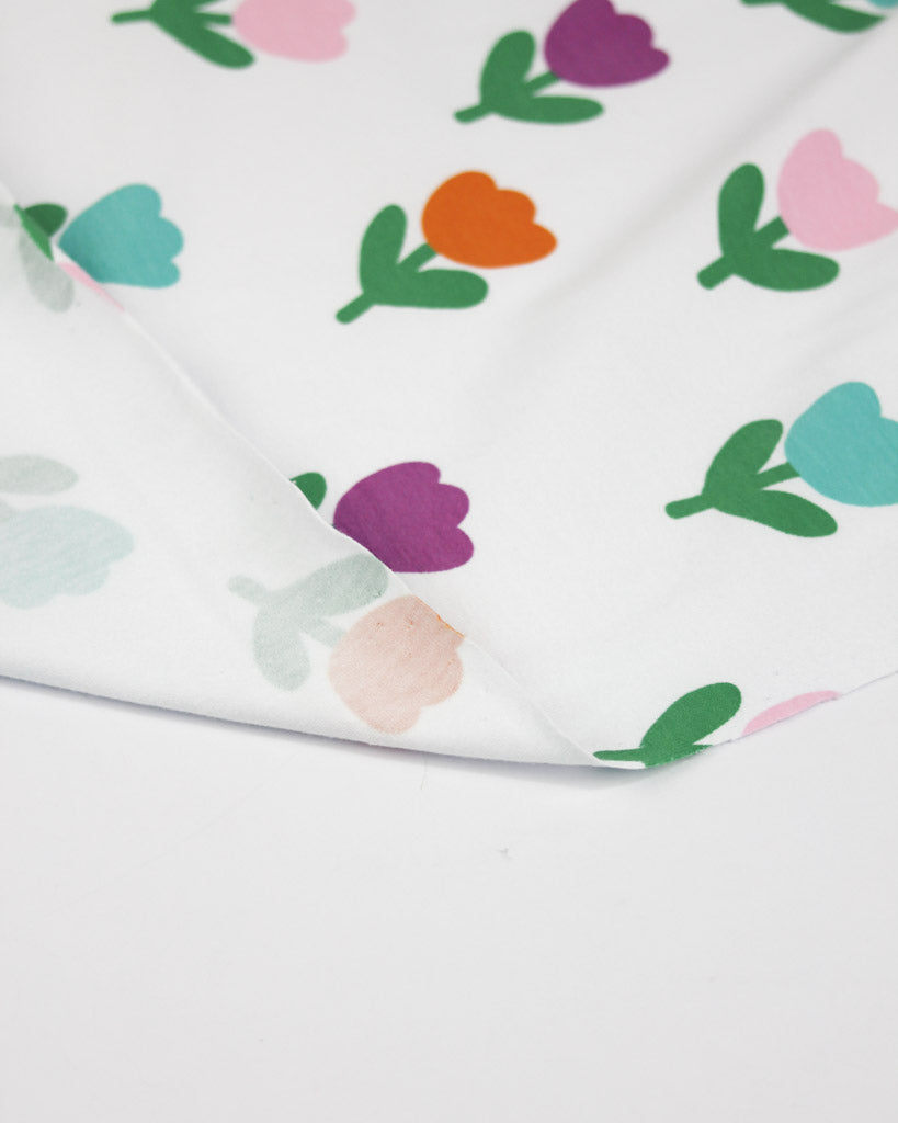 Tulip floral patterned cotton jersey fabric with colourful flowers on a white background