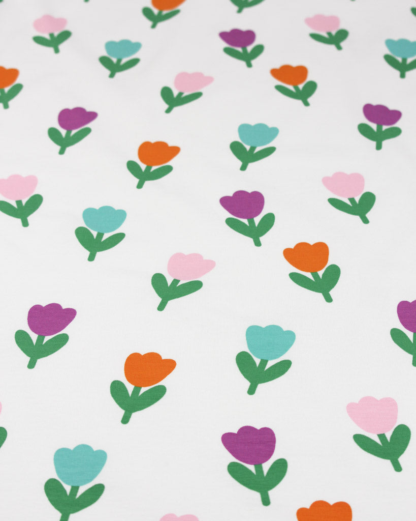 Pattern of colourful tulip flowers on a white background on a cotton jersey fabric