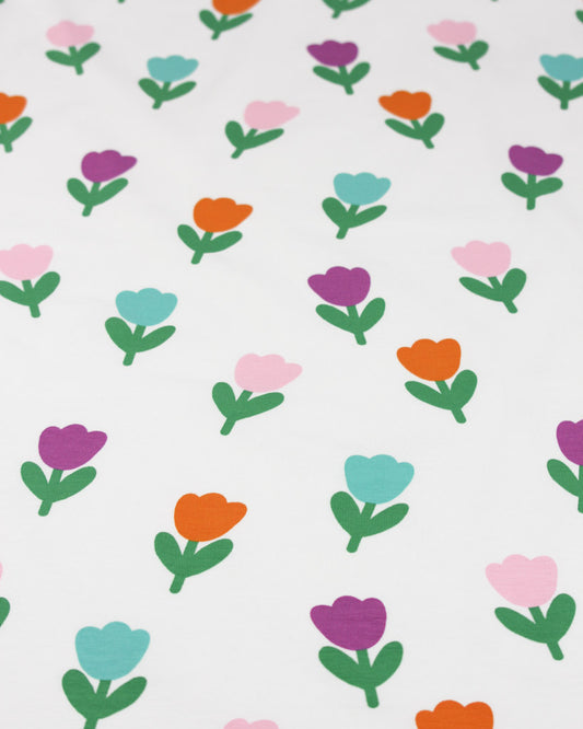 Pattern of colourful tulip flowers on a white background on a cotton jersey fabric