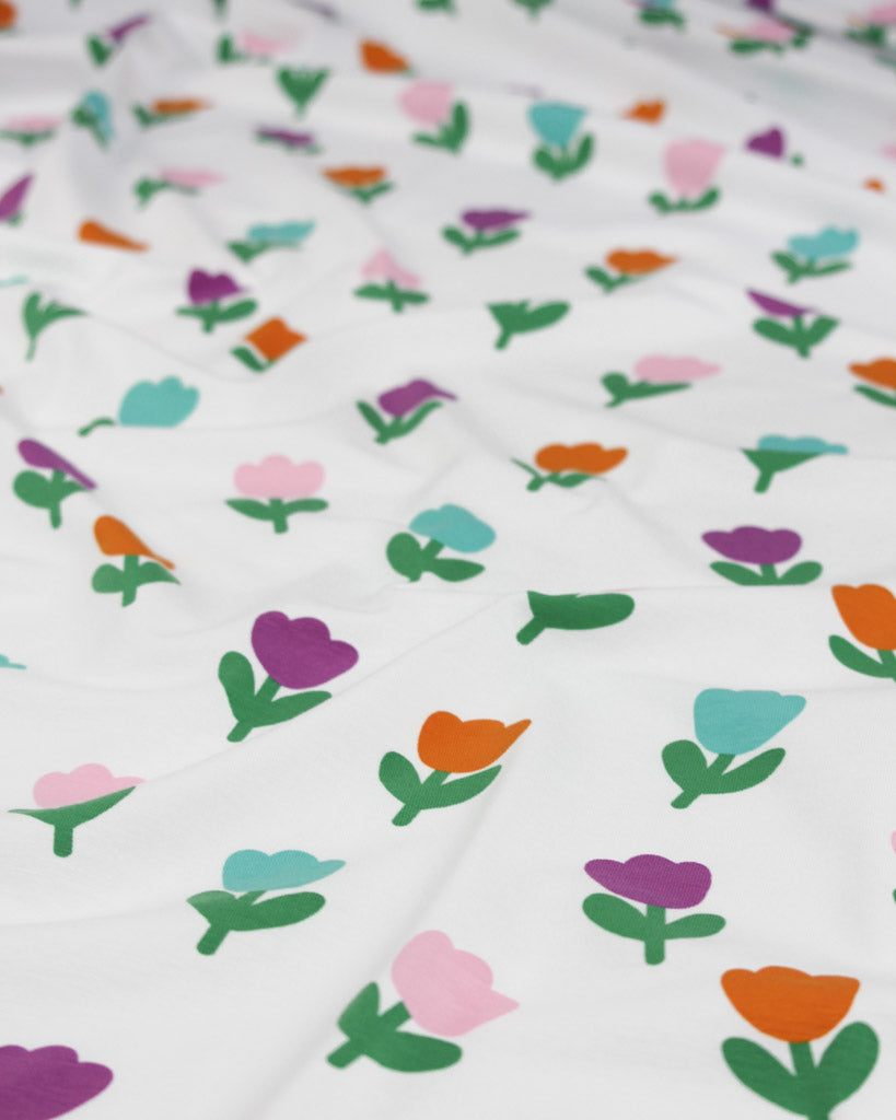 Colourful floral tulip pattern on a white background on cotton jersey fabric