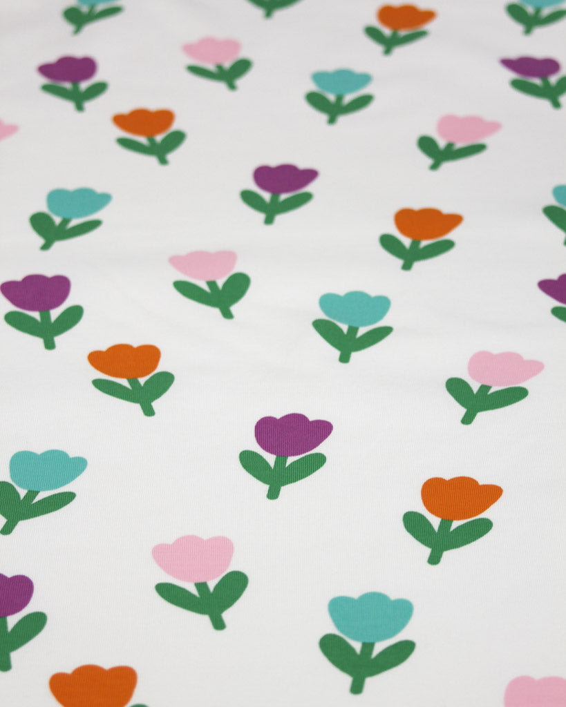 Pattern of colourful tulip flowers on a white background on cotton jersey fabric