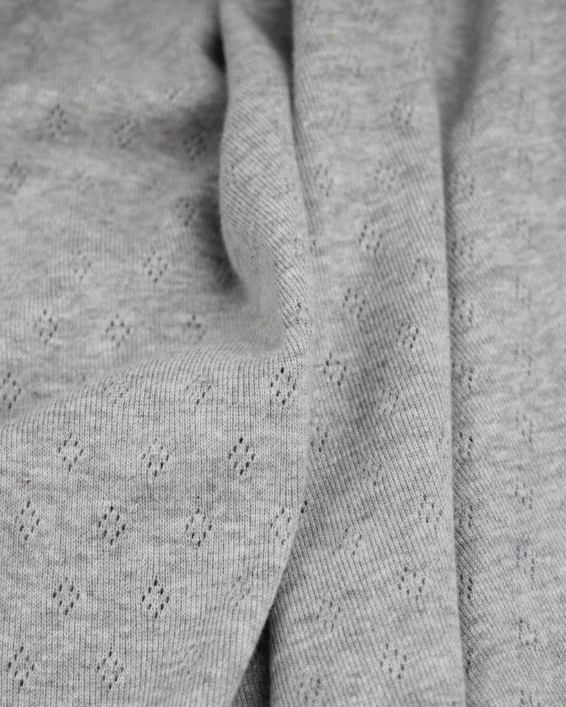 Close-up of grey knit fabric with a subtle pattern
