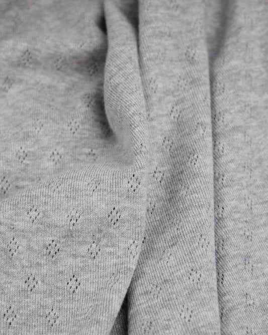 Close-up of grey knit fabric with a subtle pattern
