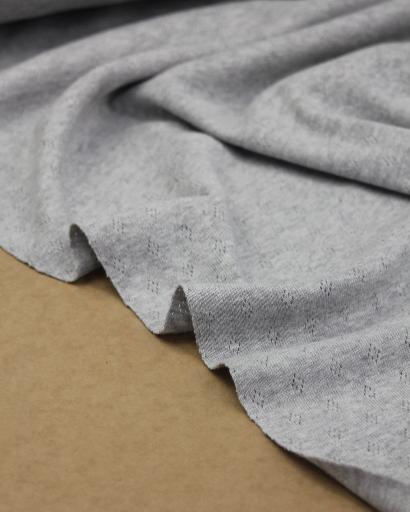 Close-up of grey knit fabric on a kraft surface