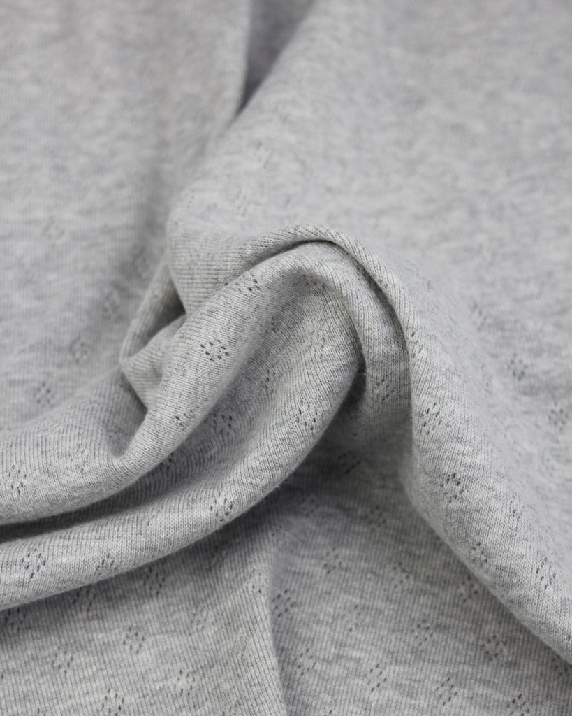 Close-up of grey knit fabric with a textured pattern