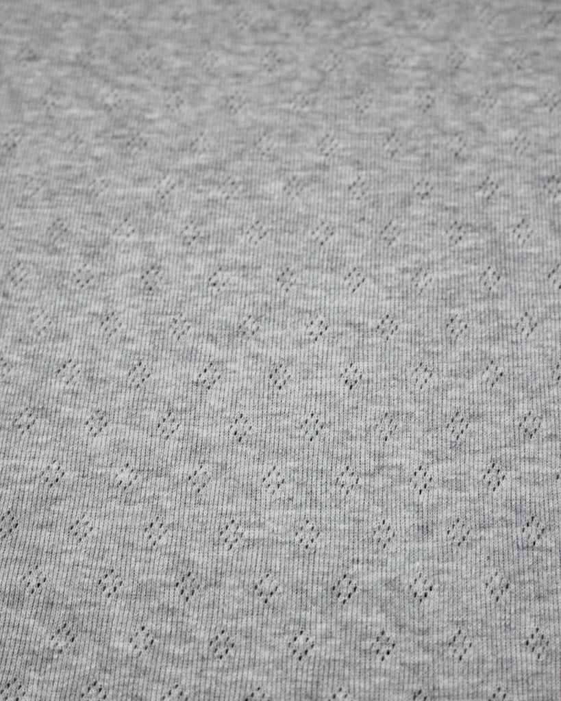 Close-up of grey knit fabric with a subtle pattern