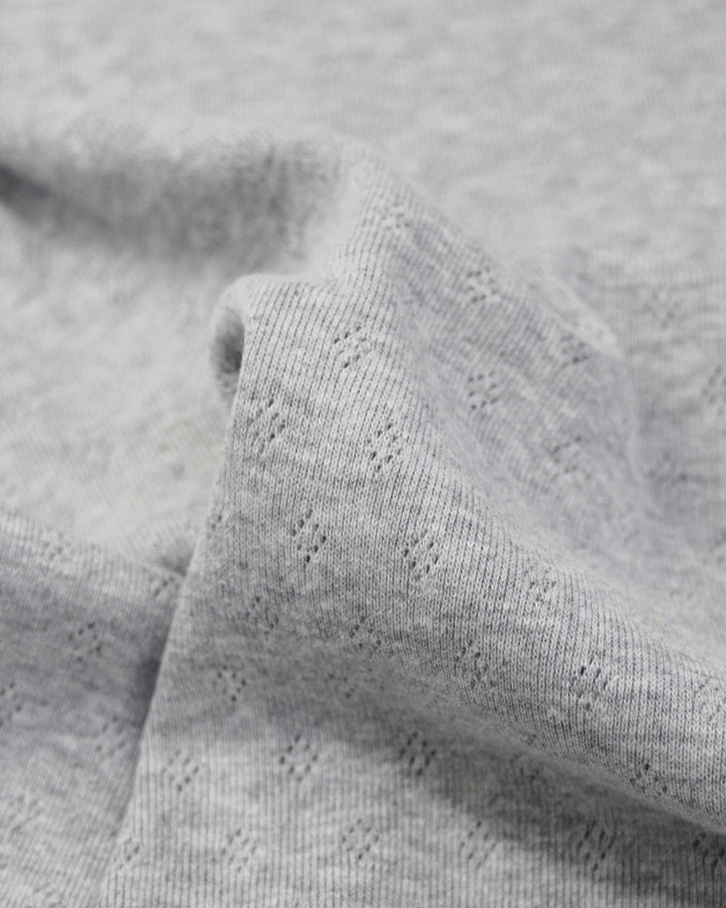 Close-up of grey pointelle textured knit fabric
