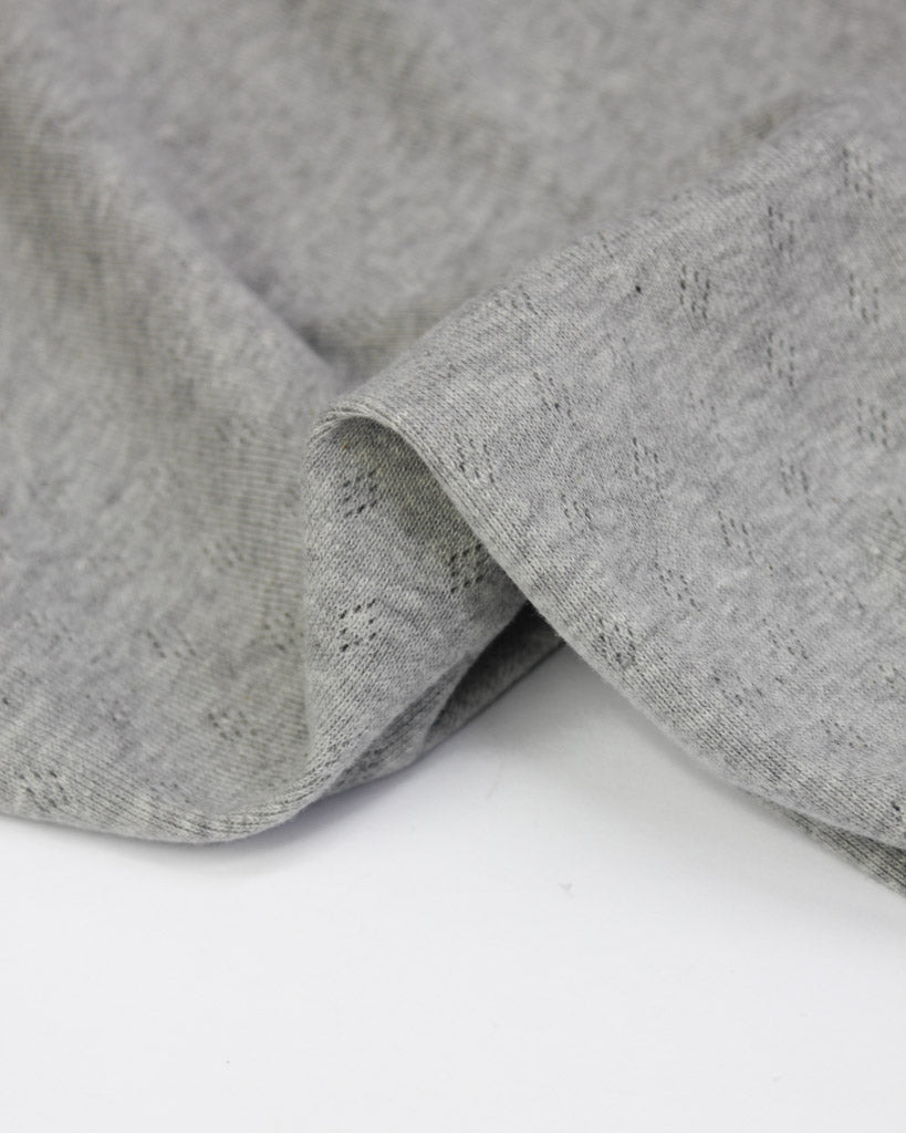 Close-up of grey pointelle fabric on a white background