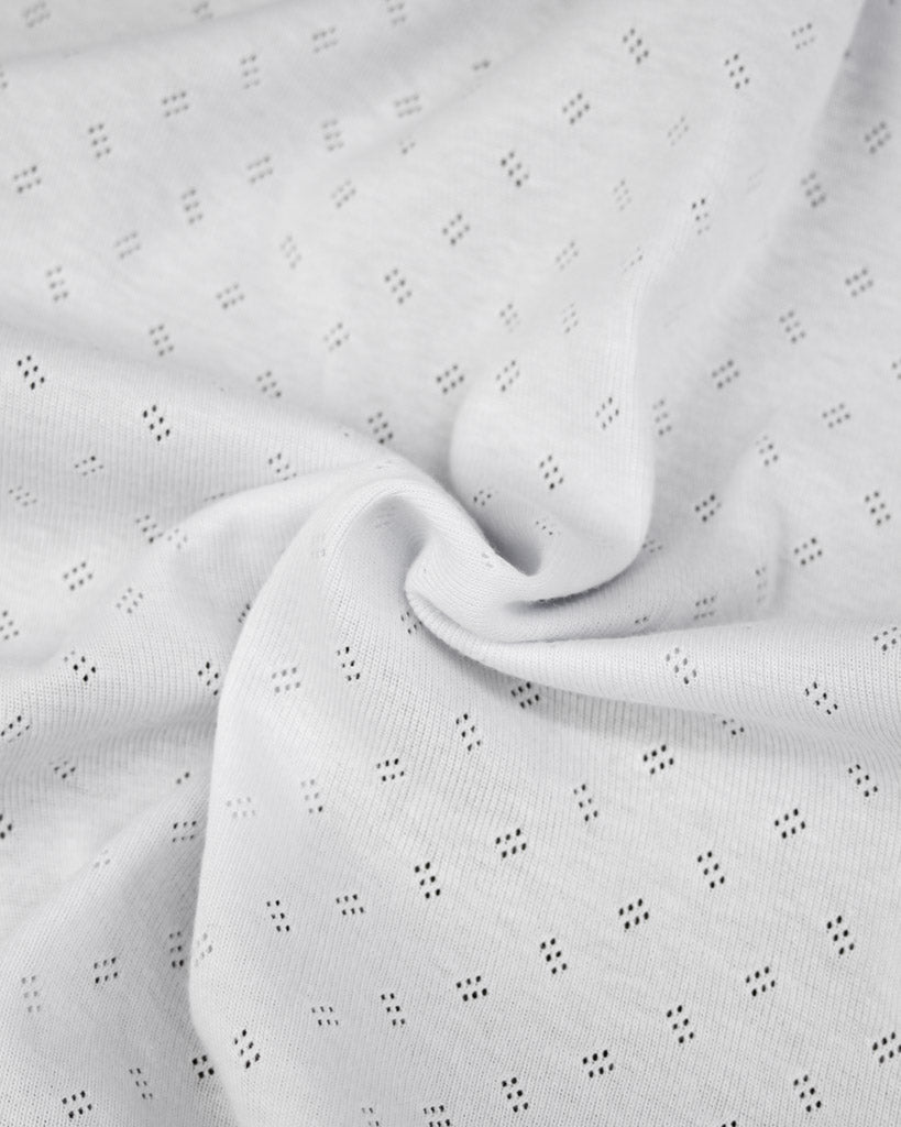 Close-up of white fabric with small pointelle details