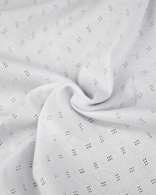 Close-up of white fabric with small pointelle details