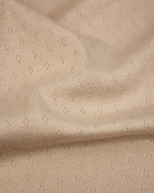Beige pointelle fabric with a subtle pattern