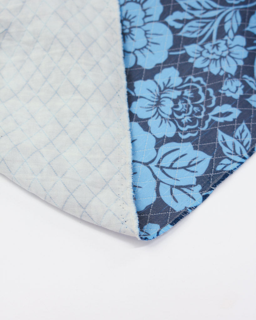 Floral patterned fabric with a quilted texture on a white background