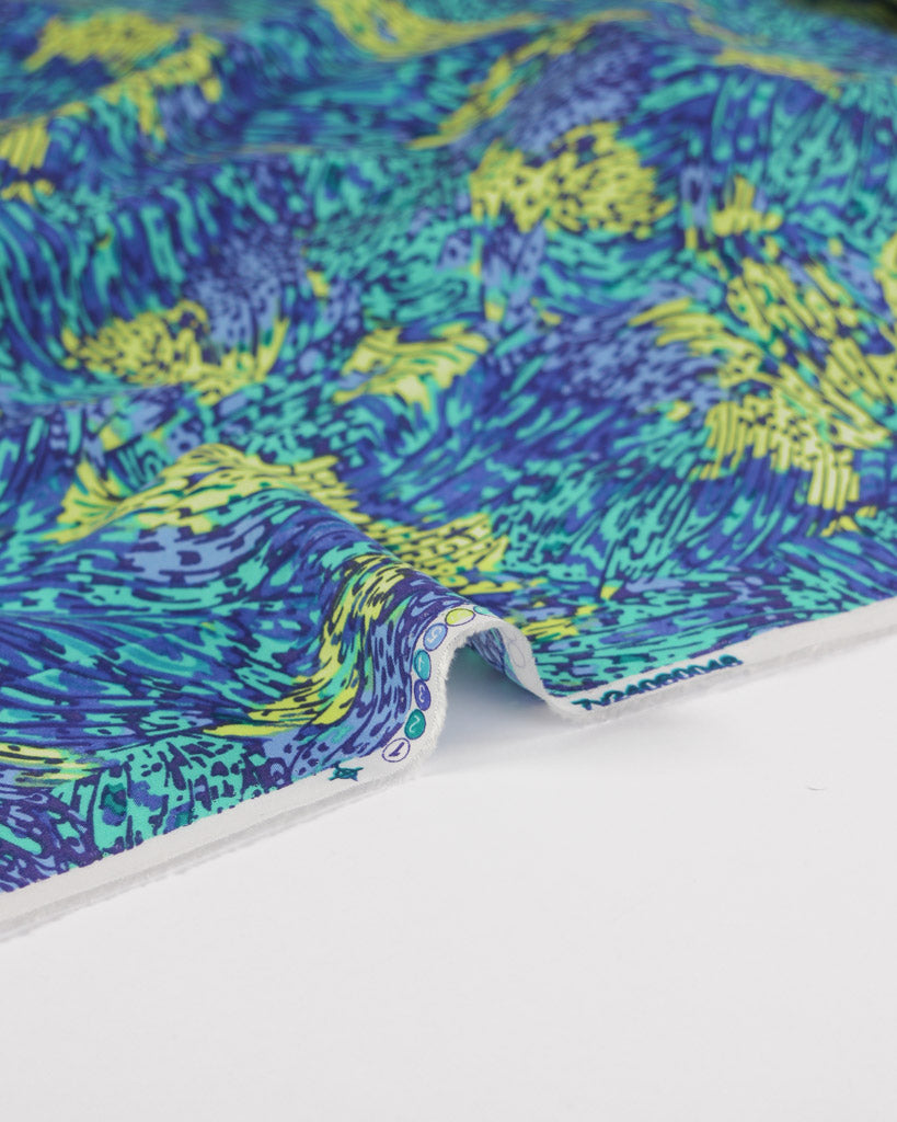 Colourful viscose lawn fabric with blue, green, and yellow pattern on a white background