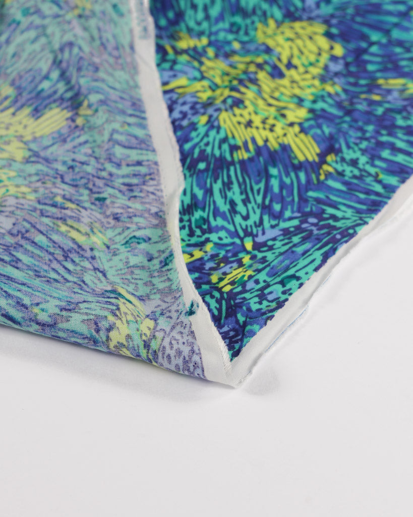 Close-up of a colorful viscose lawn fabric with abstract patterns on a white background