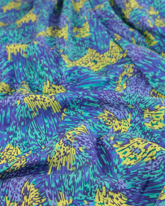 Close-up of viscose lawn fabric with blue, green, and yellow abstract pattern
