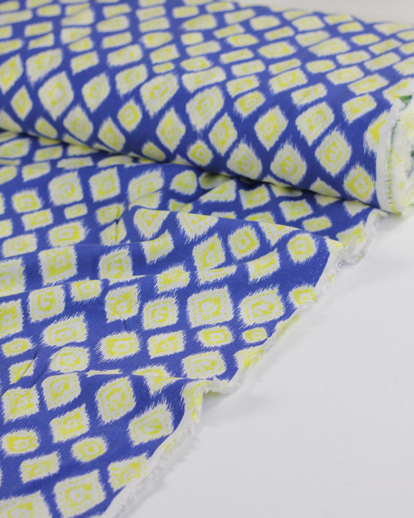 Blue viscose lawn fabric with yellow geometric pattern on a white background