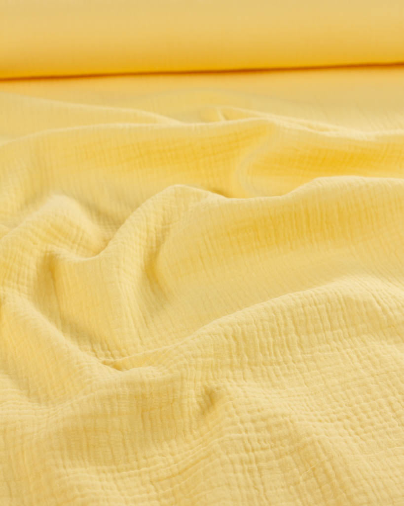 Close-up of banana yellow cotton double gauze fabric with a soft texture