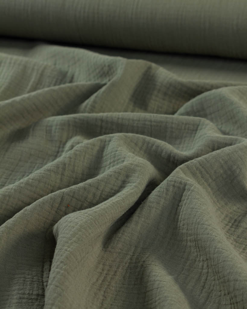 Close-up of green cotton double gauze fabric with folds