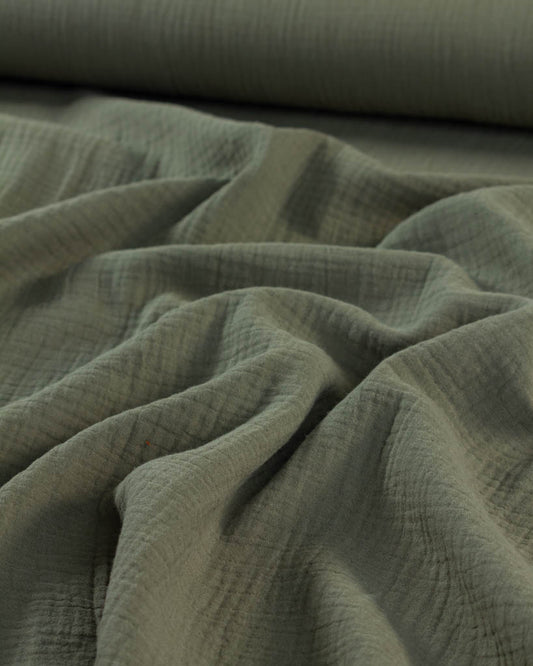 Close-up of green cotton double gauze fabric with folds