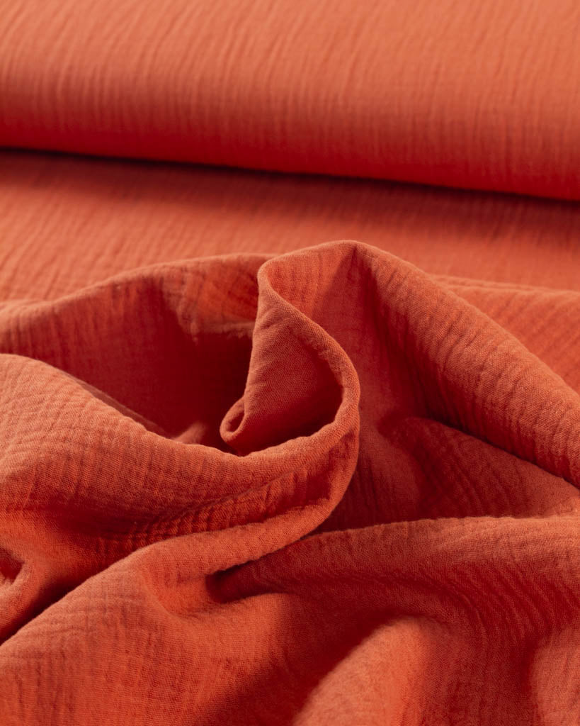 Close-up of orange cotton double gauze fabric with a textured surface