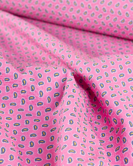 Bubblegum pink cotton seersucker fabric with a blue and yellow tiny paisley print