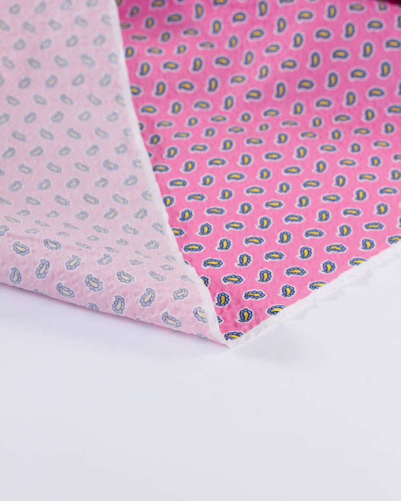 Reverse view of Posy Pure Cotton Seersucker fabric in bubblegum pink with a blue & yellow tiny paisley print