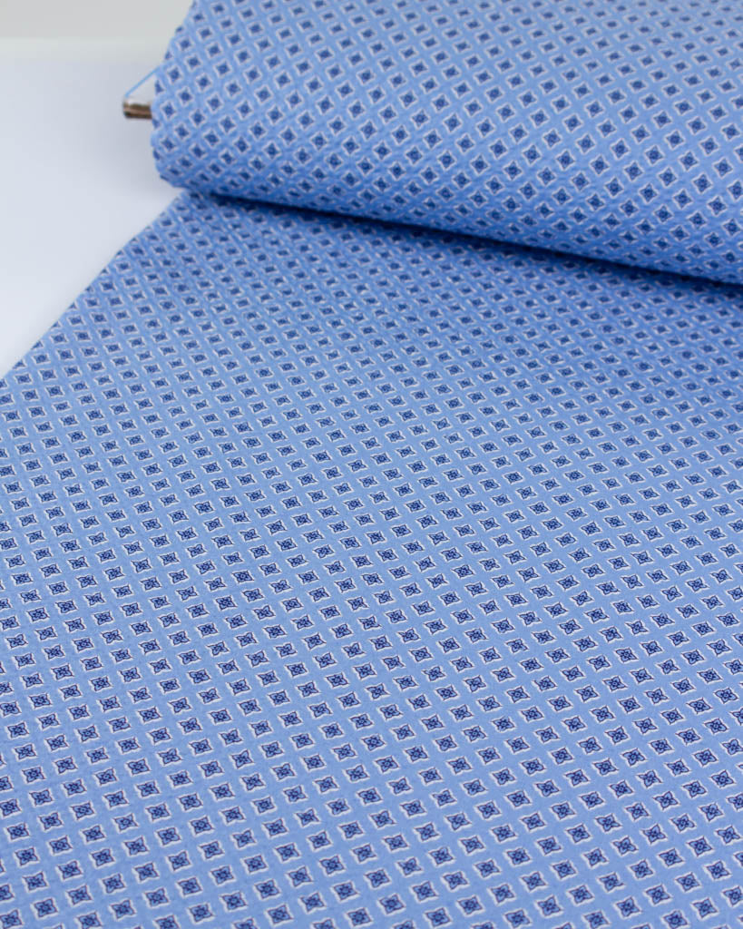 Roll of breathable sky blue cotton seersucker with a delicate forget-me-not inspired pattern