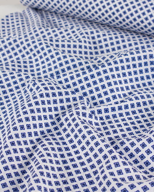 White cotton seersucker fabric with a delicate forget-me-not tile print