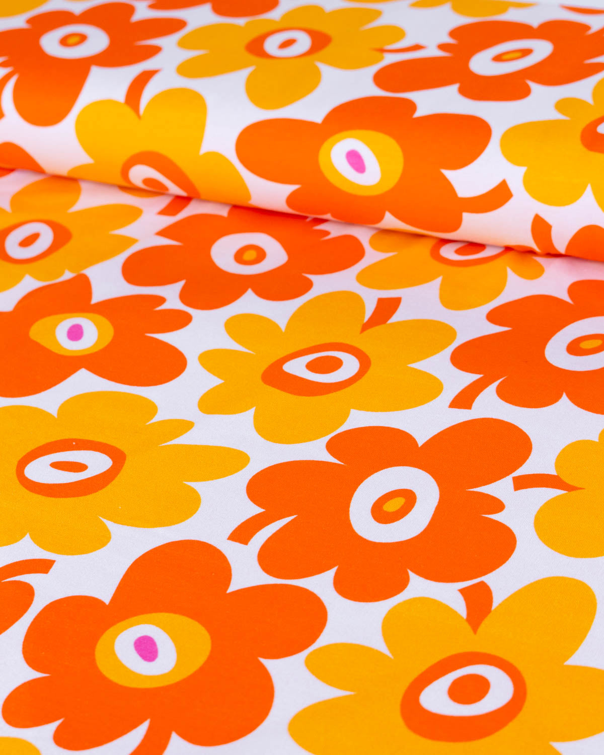 Pattern of orange and yellow flowers on a white background on a cotton jersey fabric