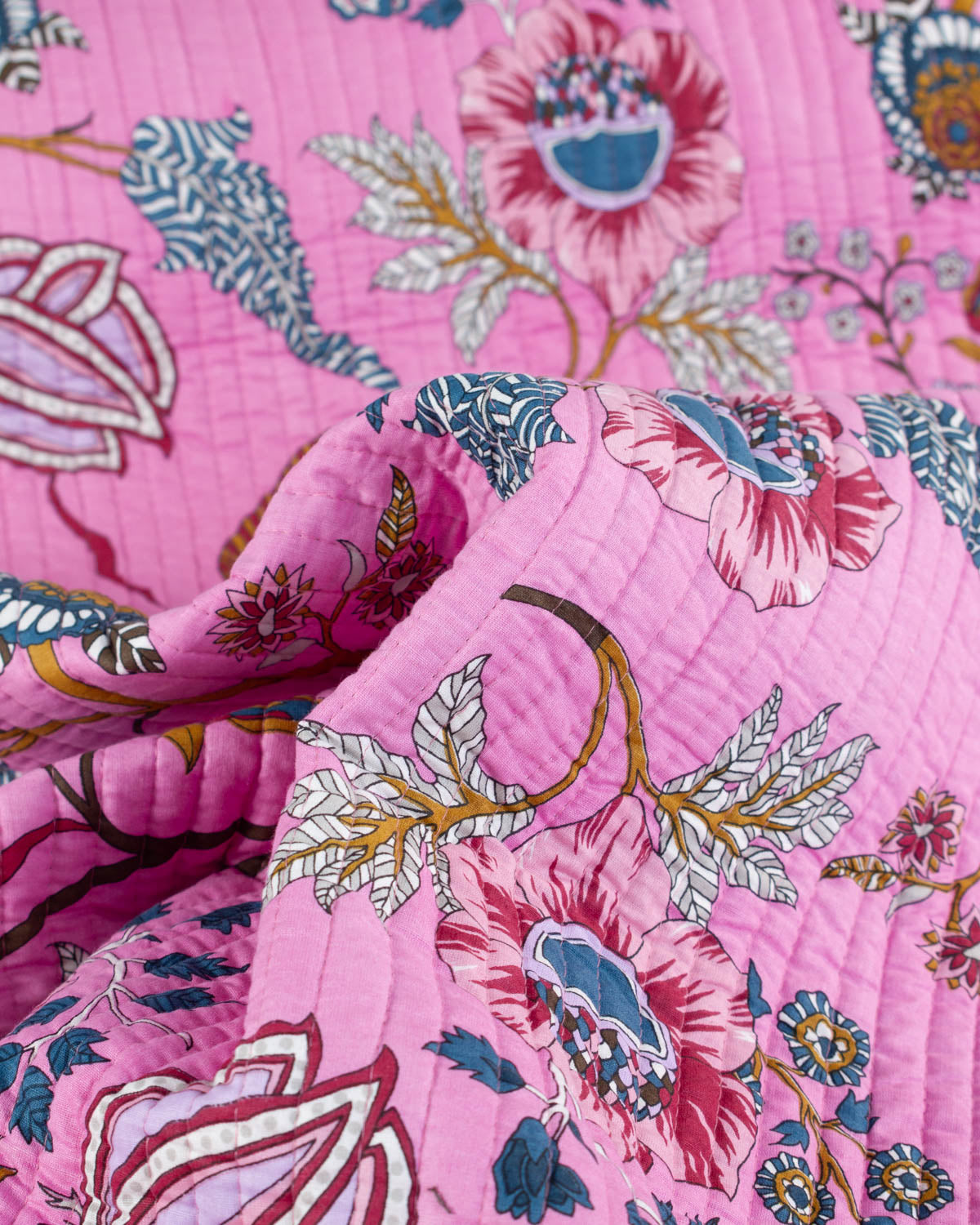 Close-up of a pink floral cotton quilt fabric with intricate patterns