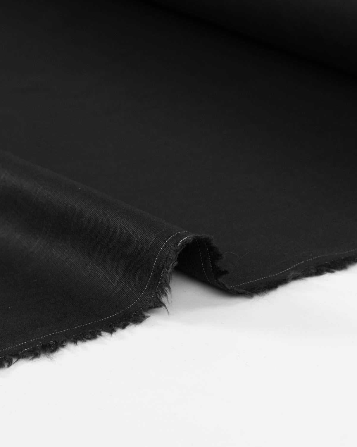 A close-up of a folded black linen fabric shown against a plain white background.