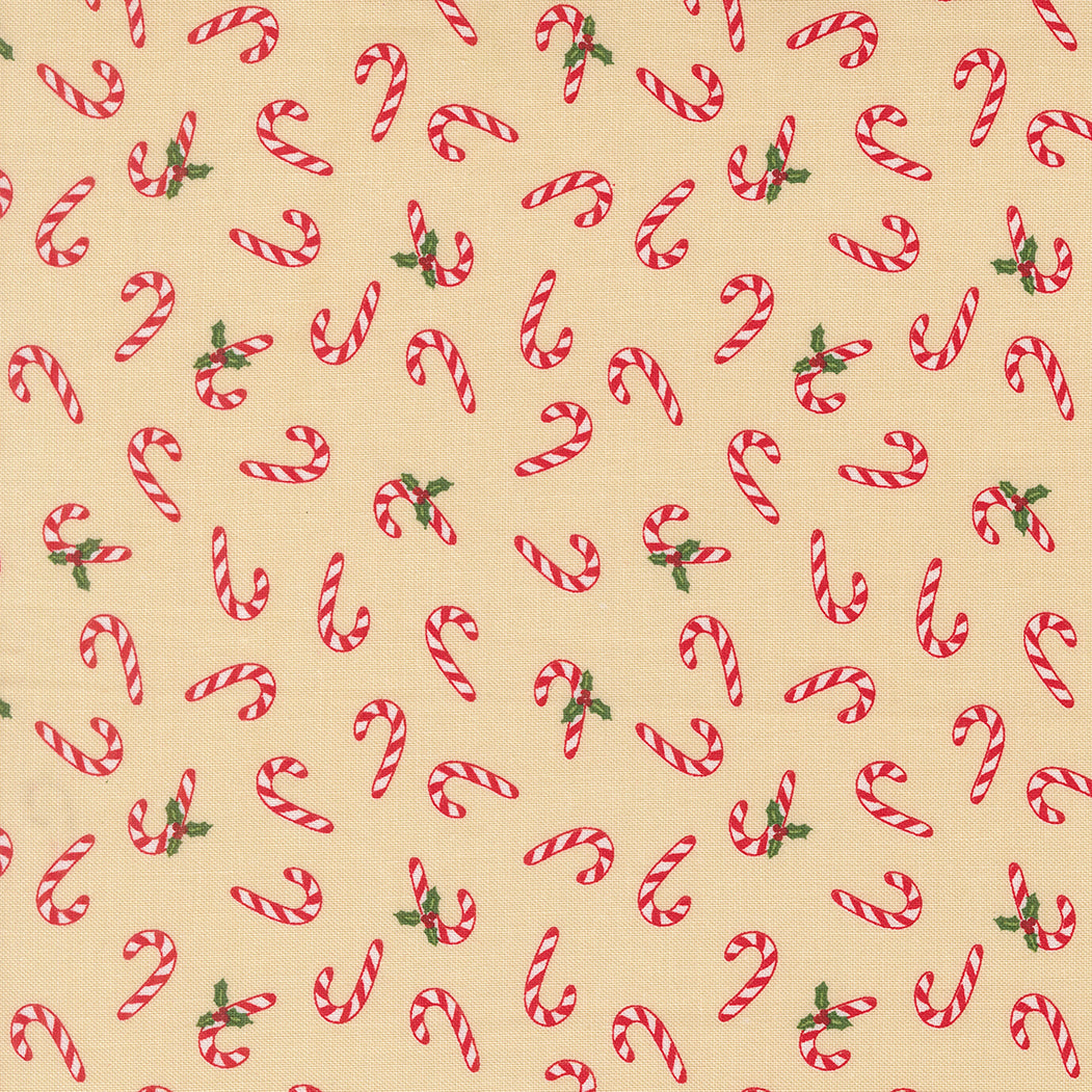 Pattern of red and white candy canes with green leaves on a beige quilting cotton