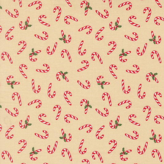 Pattern of red and white candy canes with green leaves on a beige quilting cotton