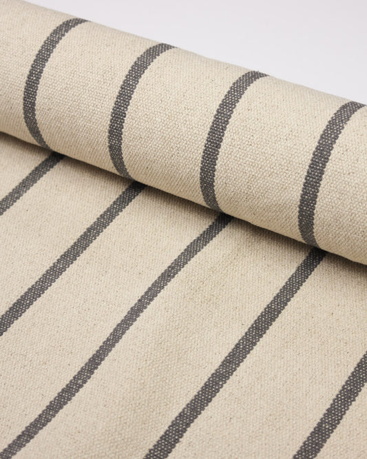 A close-up of a woven upholstery cotton with a cream base and mid grey vertical stripes 