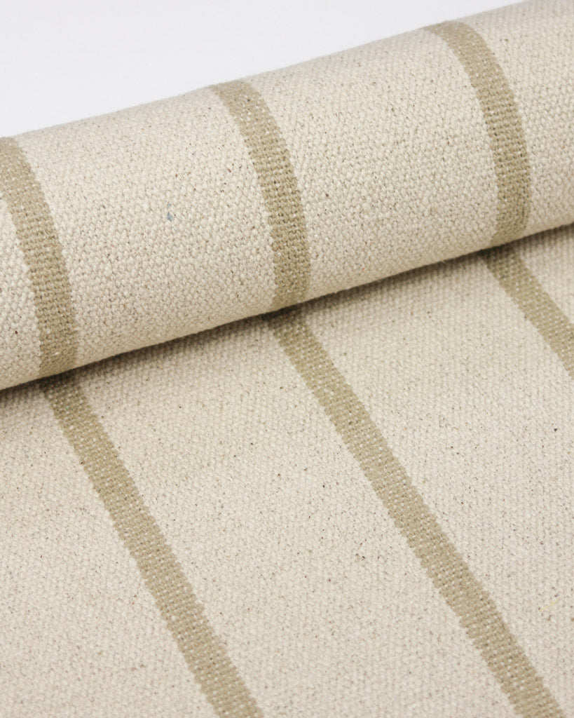 A close-up of a woven cotton upholstery fabric featuring a warm beige base with vertical taupe stripes.