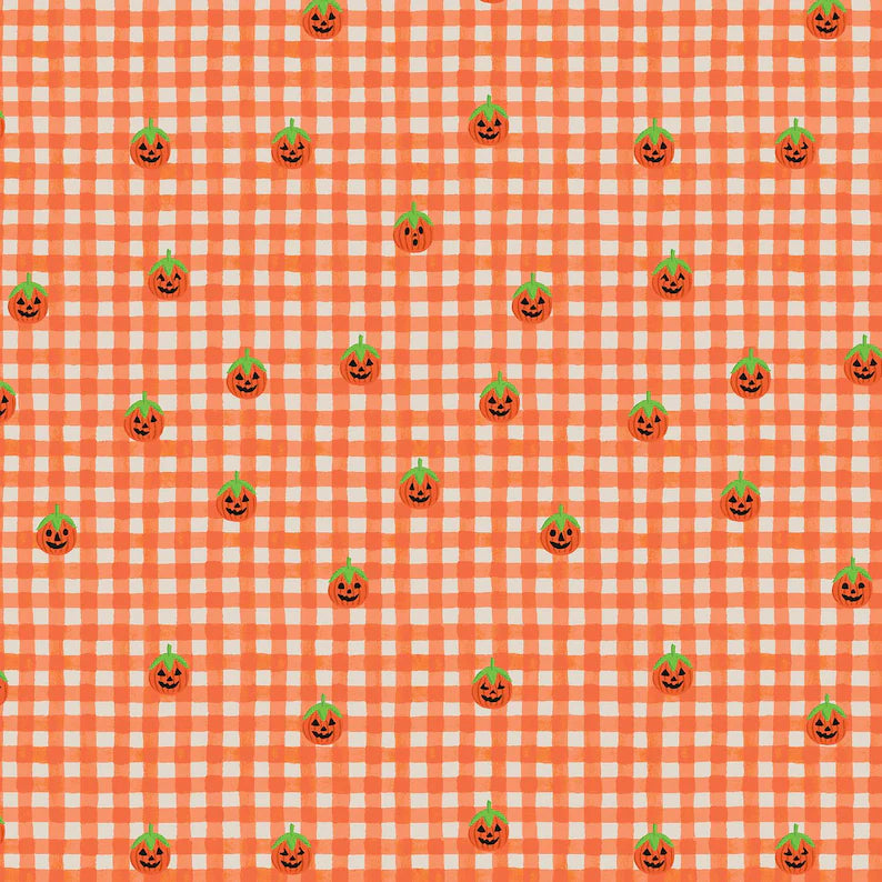 A repeating Halloween pattern featuring small orange jack-o'-lantern pumpkins with green tops on an orange and white gingham check quilting cotton