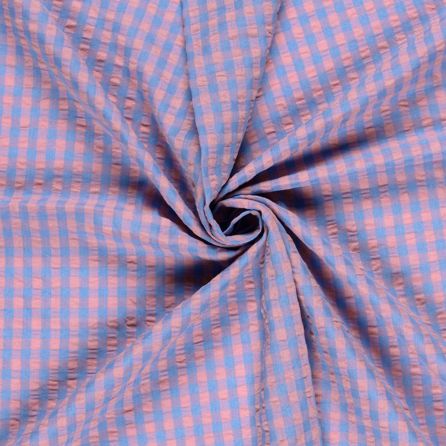 Close-up of blue and pink checkered fabric in a swirl.