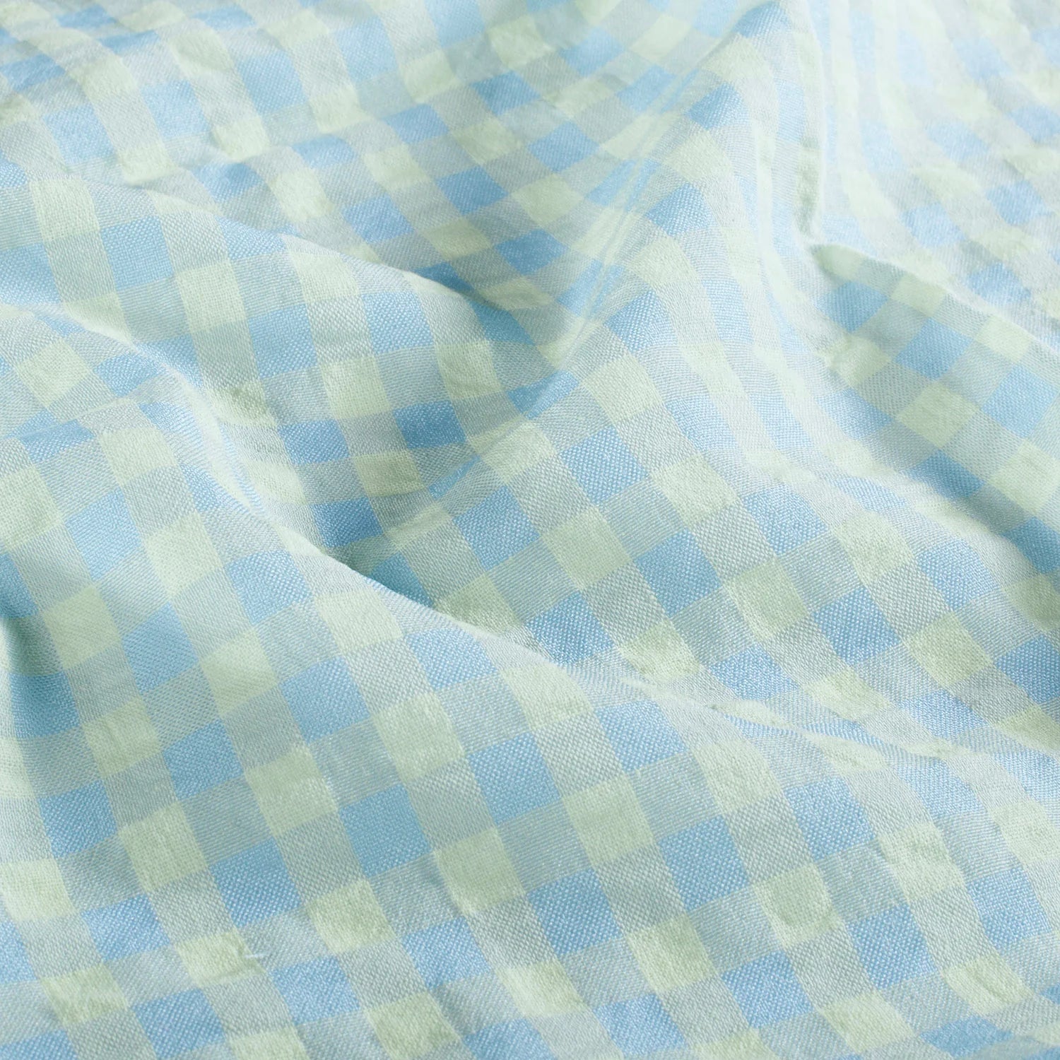 Light blue and pale yellow gingham checkered fabric with a soft, crinkled texture.