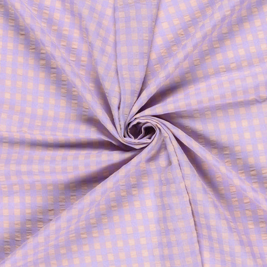 Folded fabric with a subtle check pattern on a light purple background