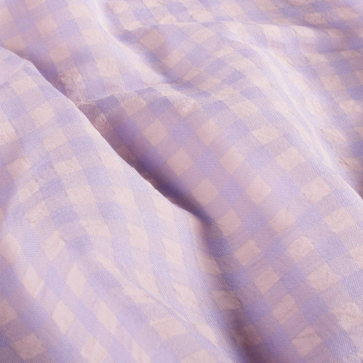 Close-up of checkered fabric with a soft purple and beige pattern
