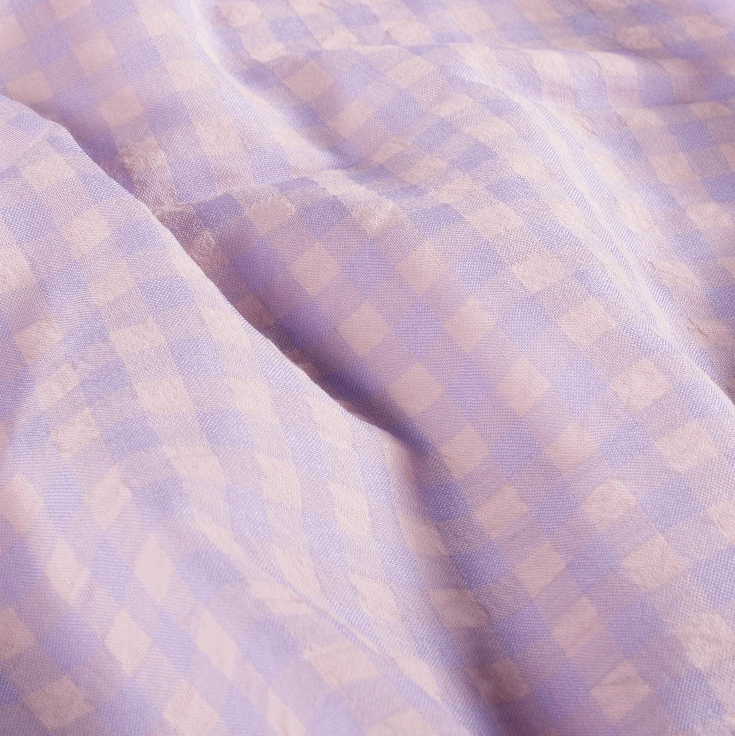 Close-up of checkered fabric with a soft purple and beige pattern