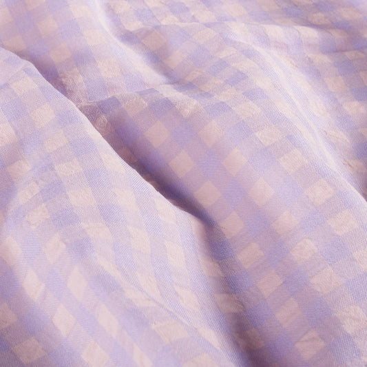 Close-up of checkered fabric with a soft purple and beige pattern
