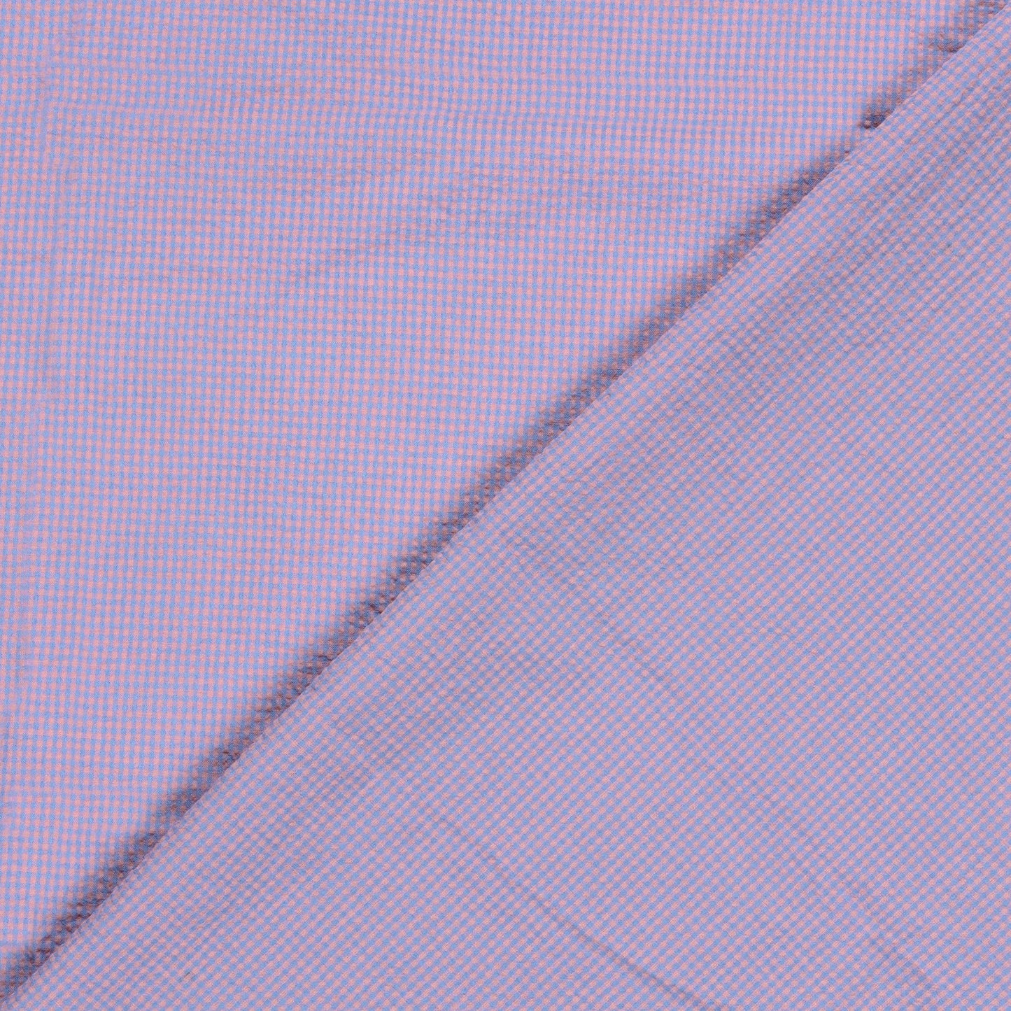 A close-up of a pink and blue gingham micro-check patterned fabric, folded diagonally across the frame.
