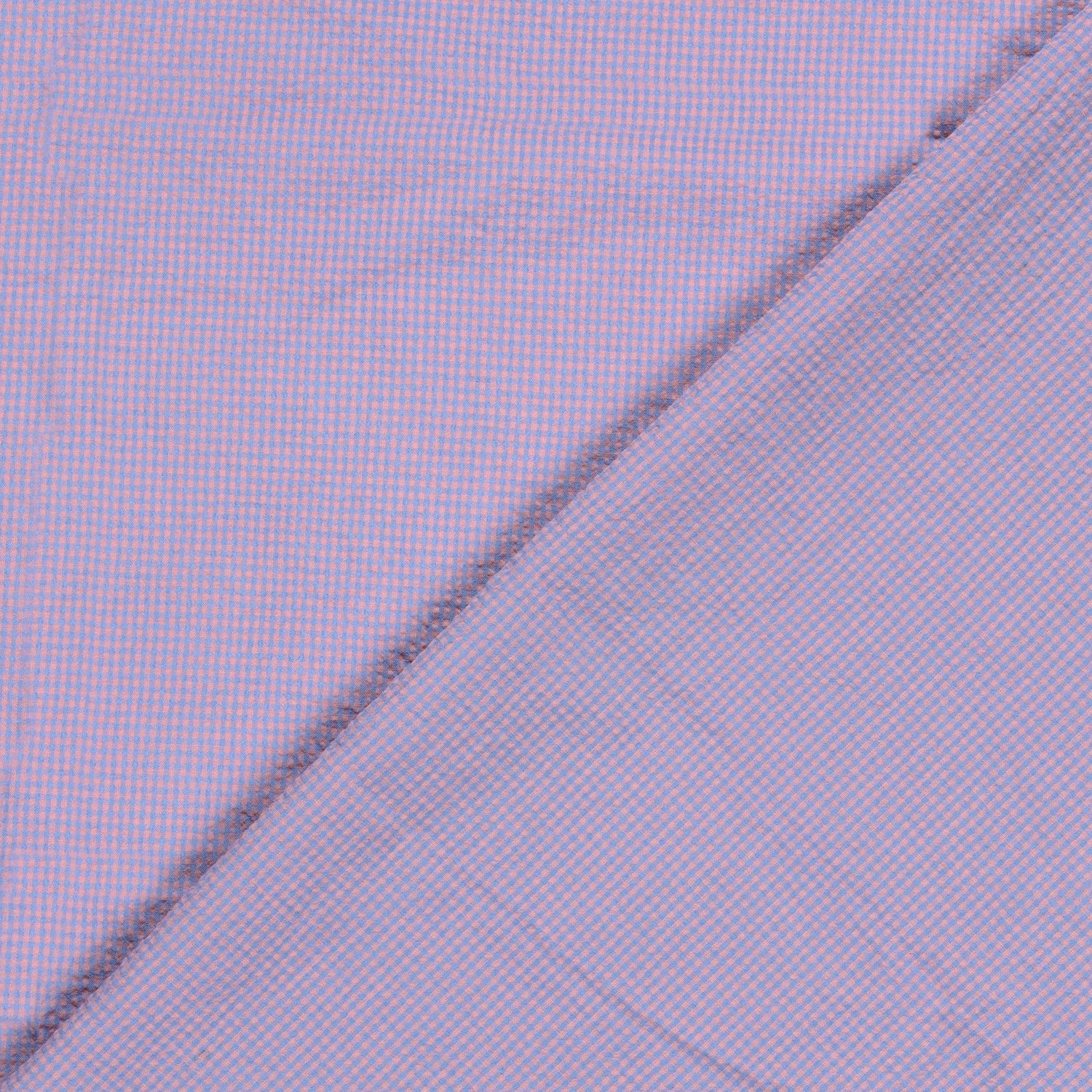 A close-up of a pink and blue gingham micro-check patterned fabric, folded diagonally across the frame.