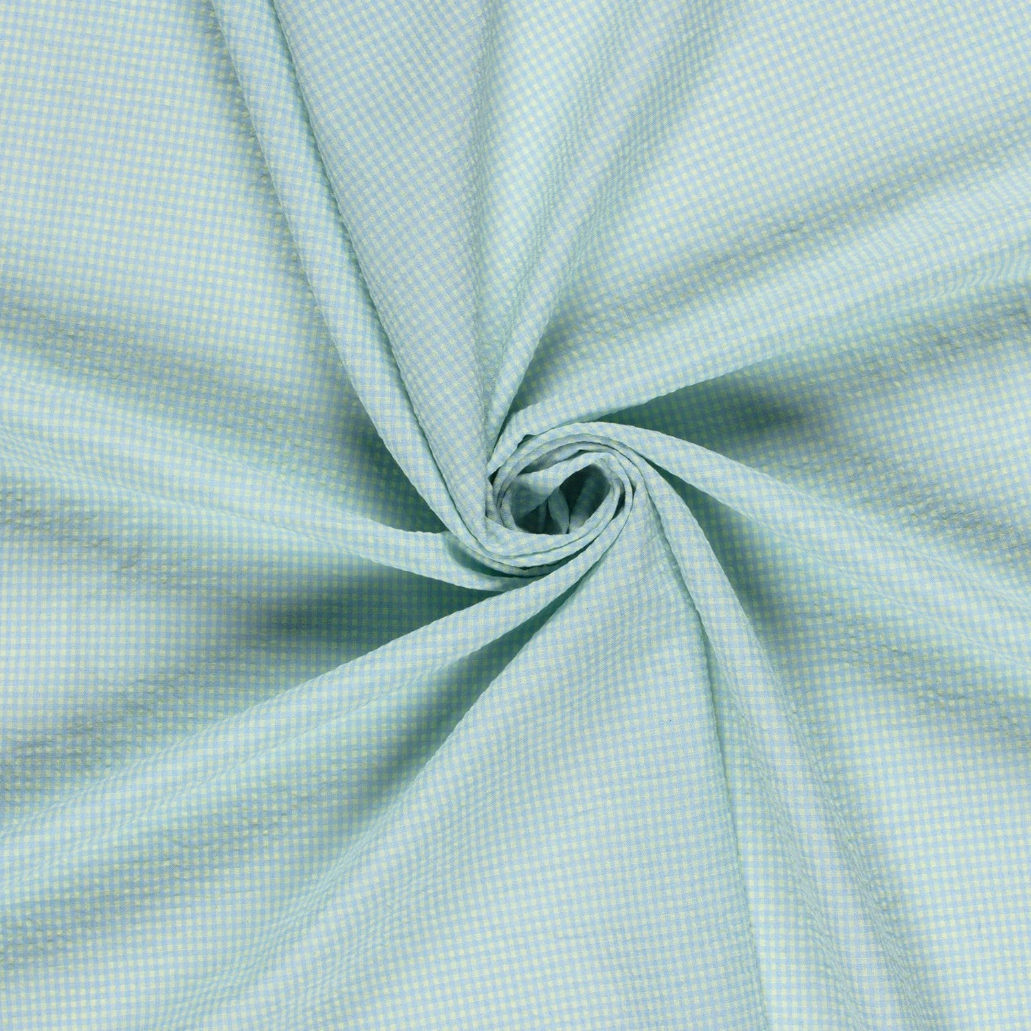 A close-up of light blue and yellow fabric with a fine micro-check pattern, artistically swirled in the center to show its drape and texture.