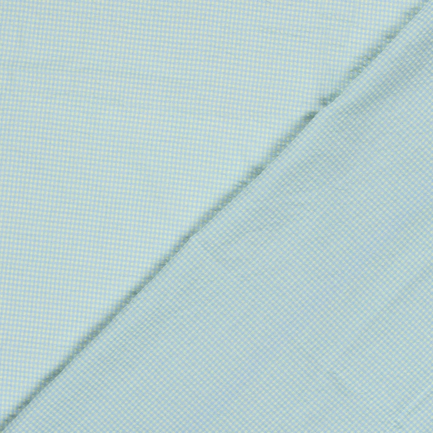 A close-up of a light blue and yellow fabric with a fine micro-check pattern, folded diagonally across the frame.
