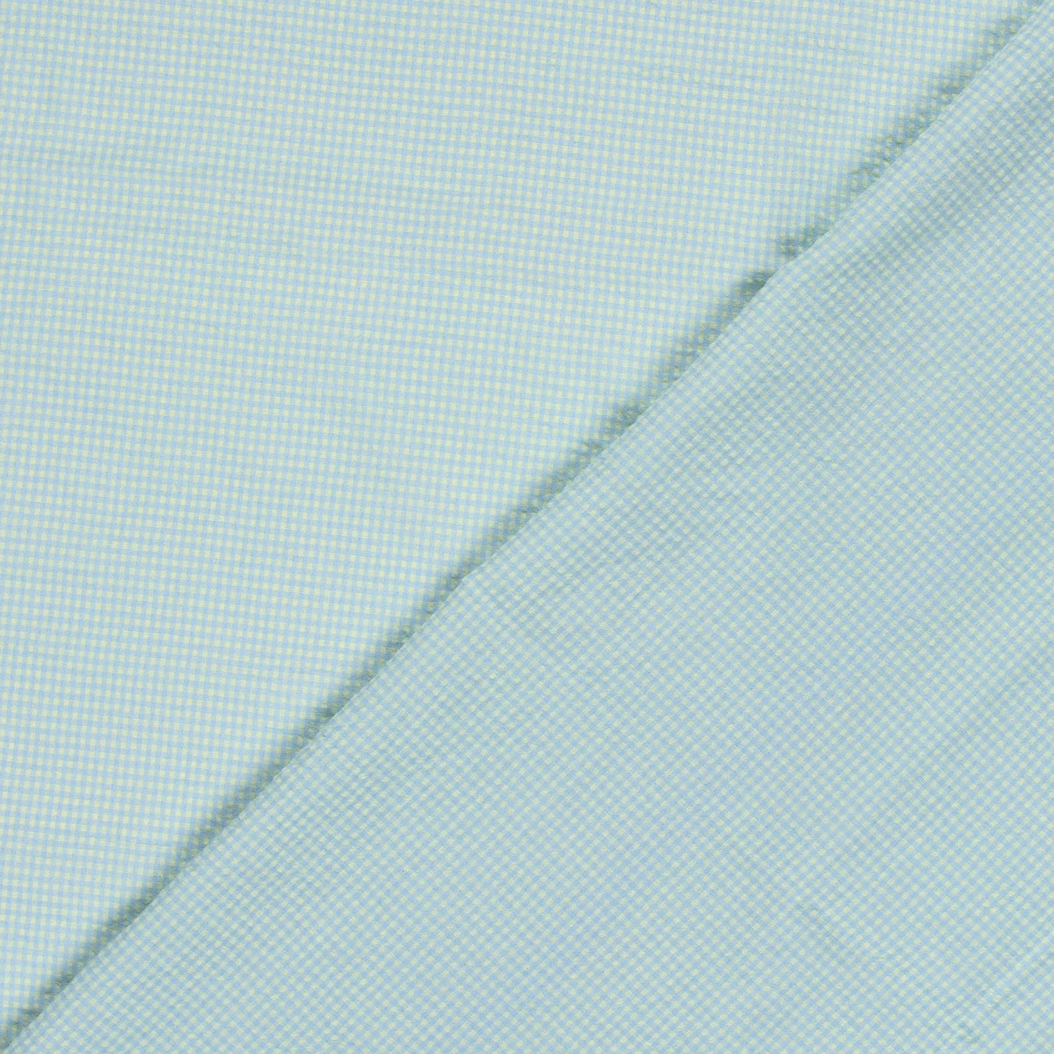 A close-up of a light blue and yellow fabric with a fine micro-check pattern, folded diagonally across the frame.