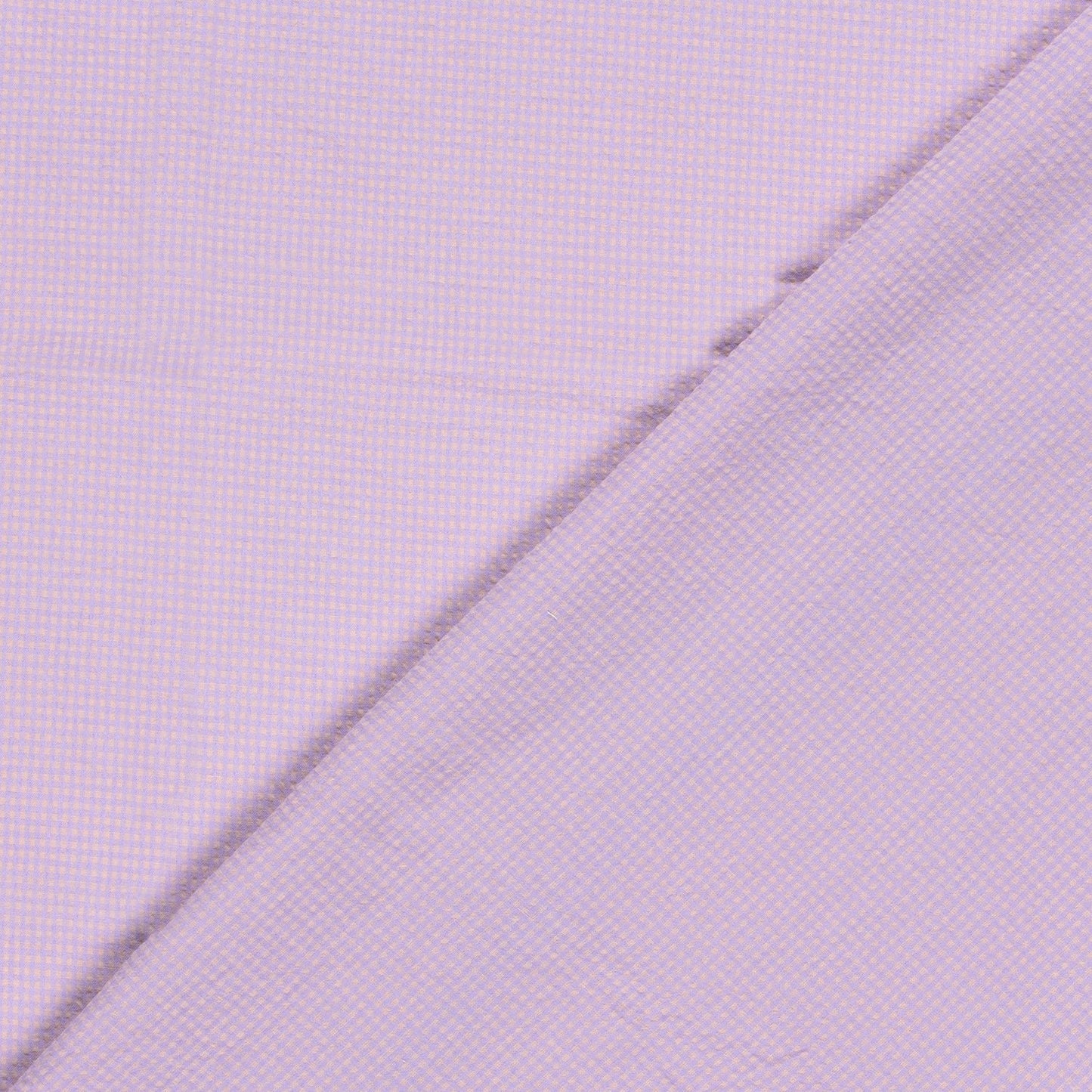 A close-up of a light lavender purple fabric with a fine micro-check pattern, folded diagonally across the frame.