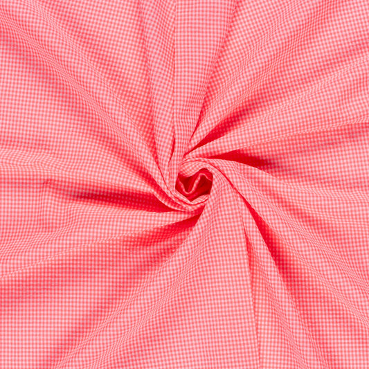 A close-up of pink and white gingham fabric arranged in a spiral swirl, showing the texture and pattern of the material.