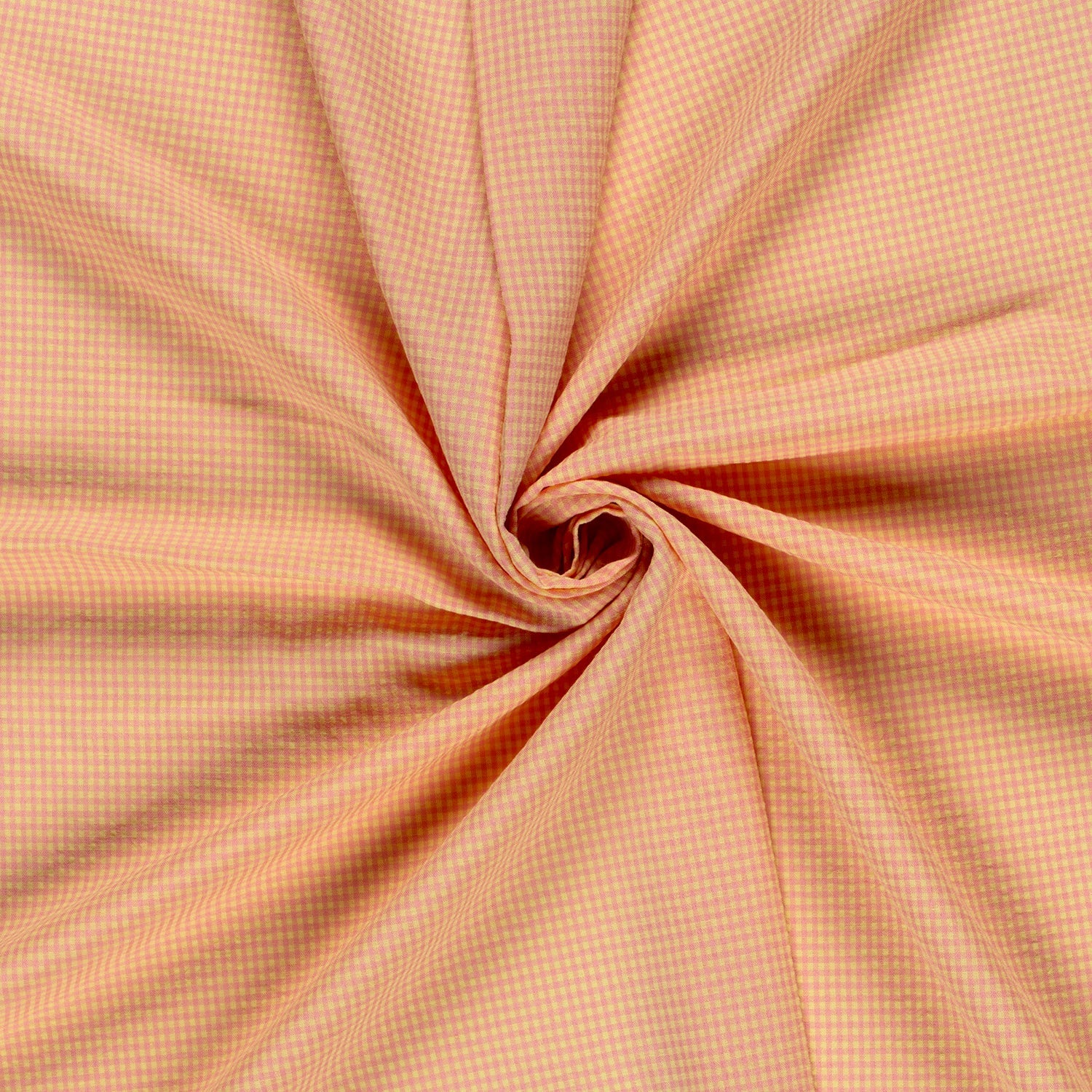 A close-up of pink and yellow fabric with a fine gingham check pattern, arranged in a spiral drape to show its texture and color.